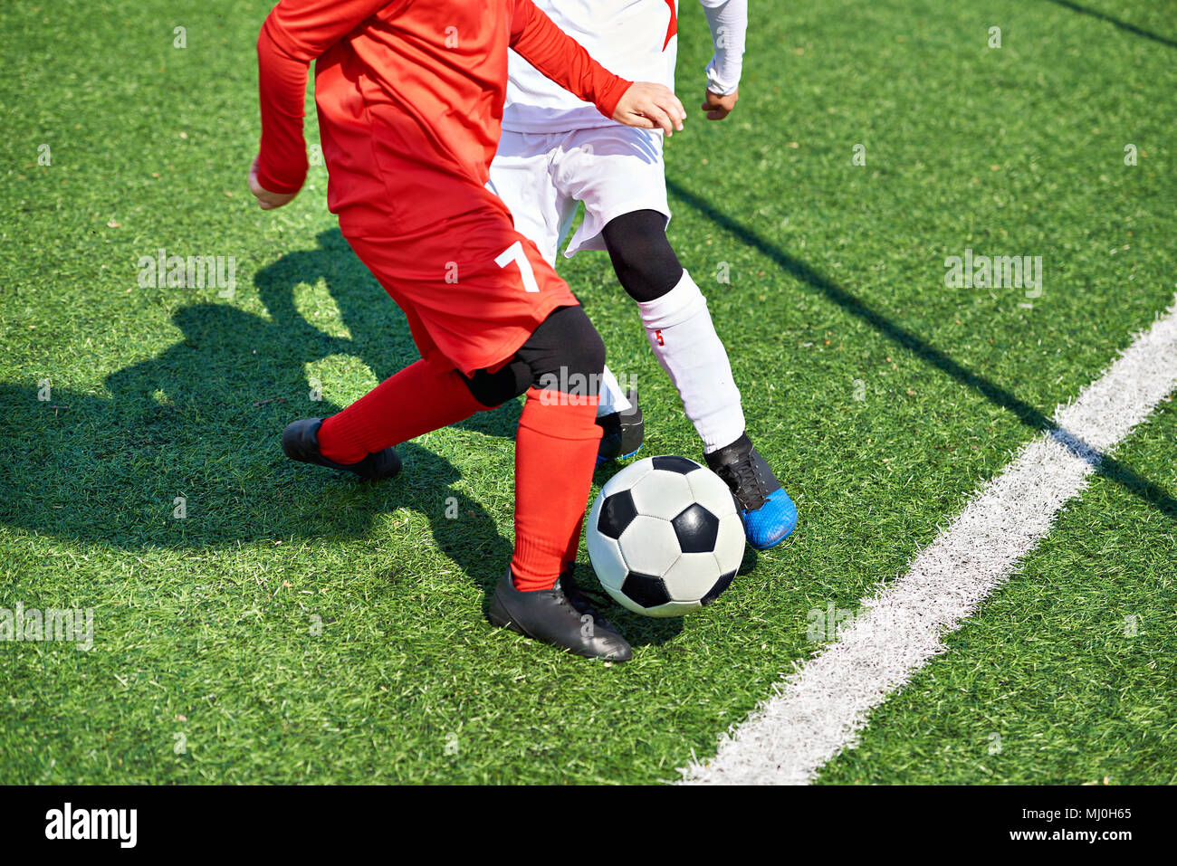 Kind Fußball-Spieler und Ball auf dem Fußballplatz Stockfoto