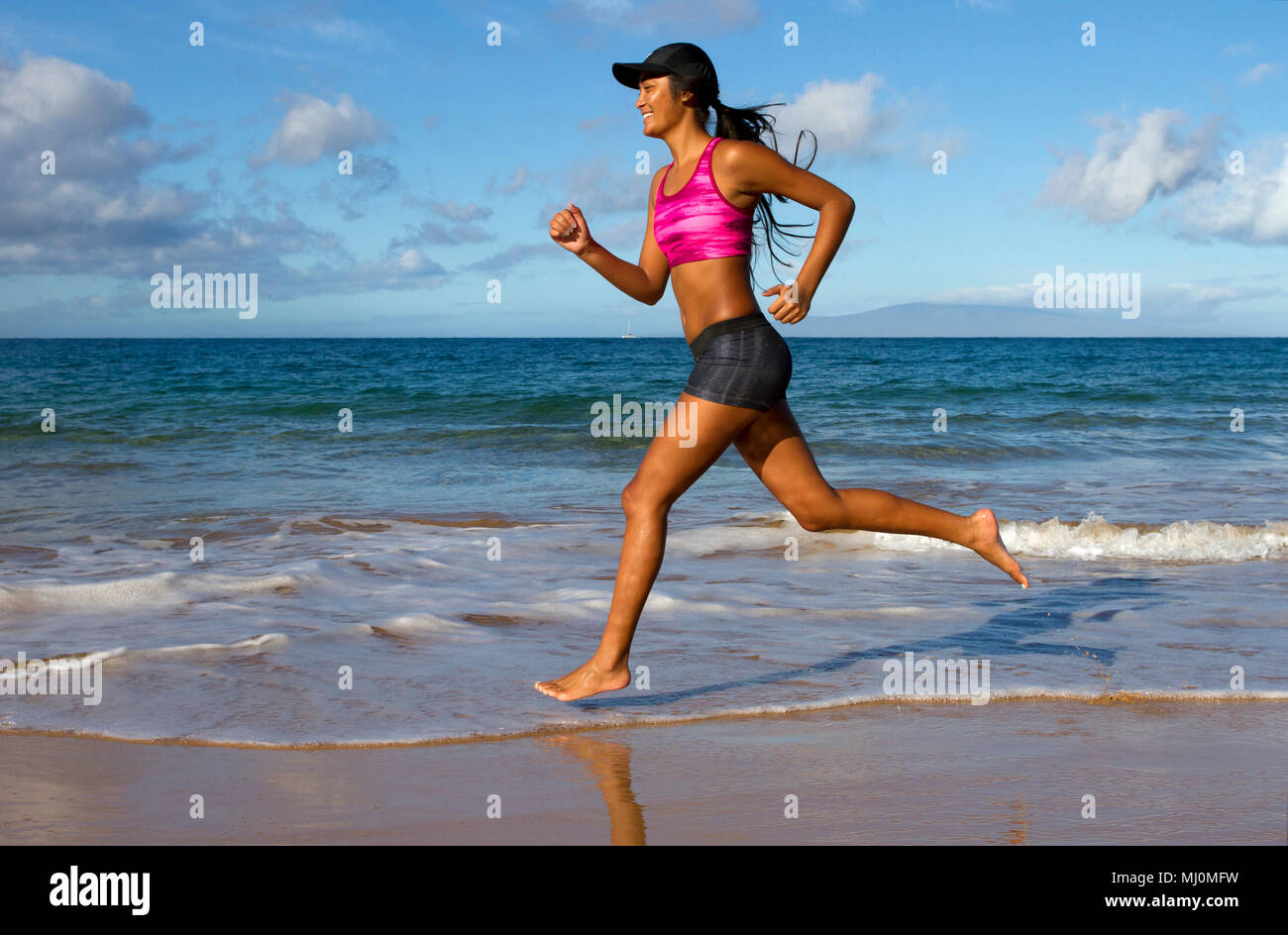 Hispanic weiblichen läuft am Strand in Kihei, Maui, Hawaii. Stockfoto