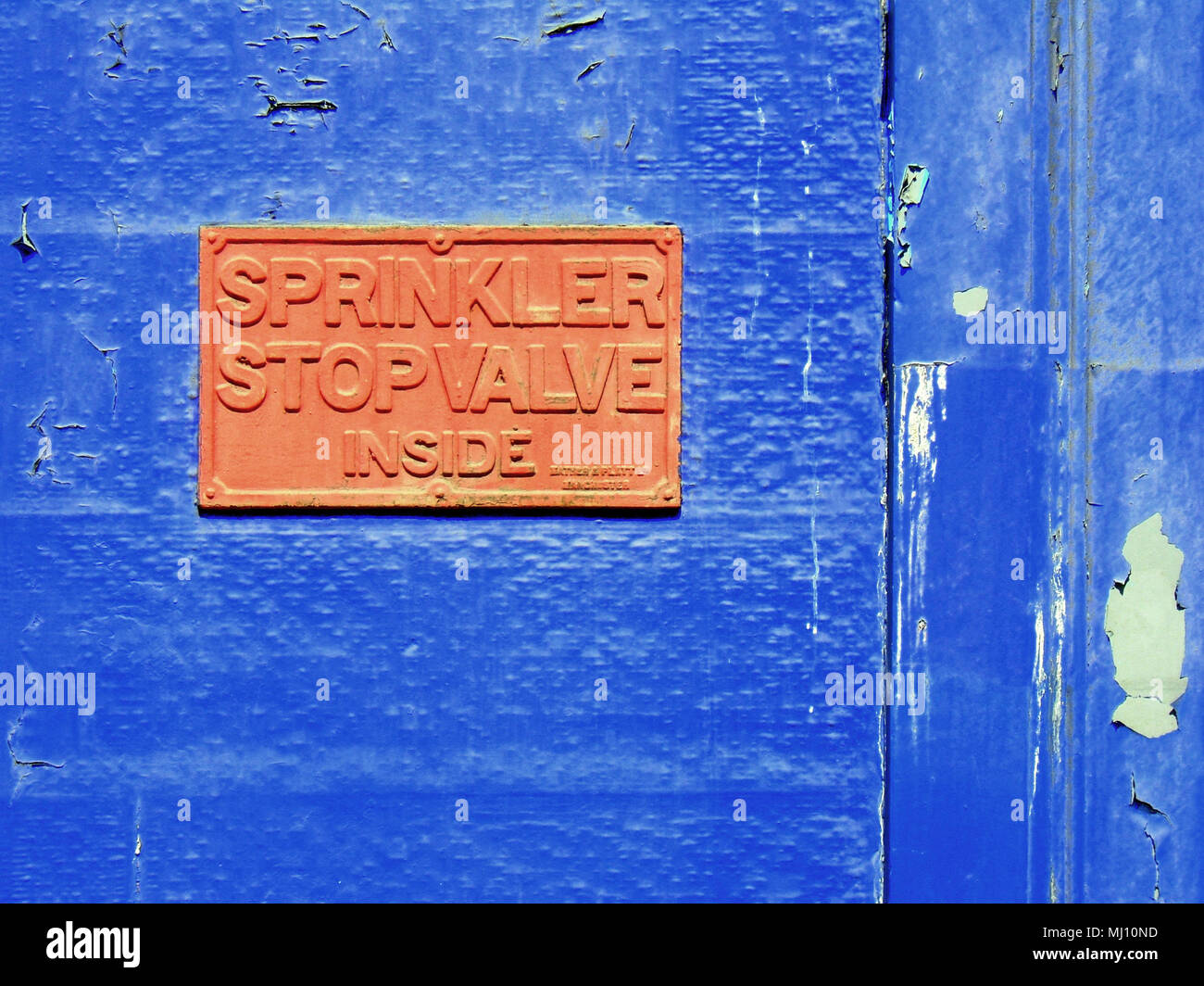 Sprinklerschutz stop Ventil im Inneren zeichen Orange auf Blau Gebäude Hintergrund Stockfoto