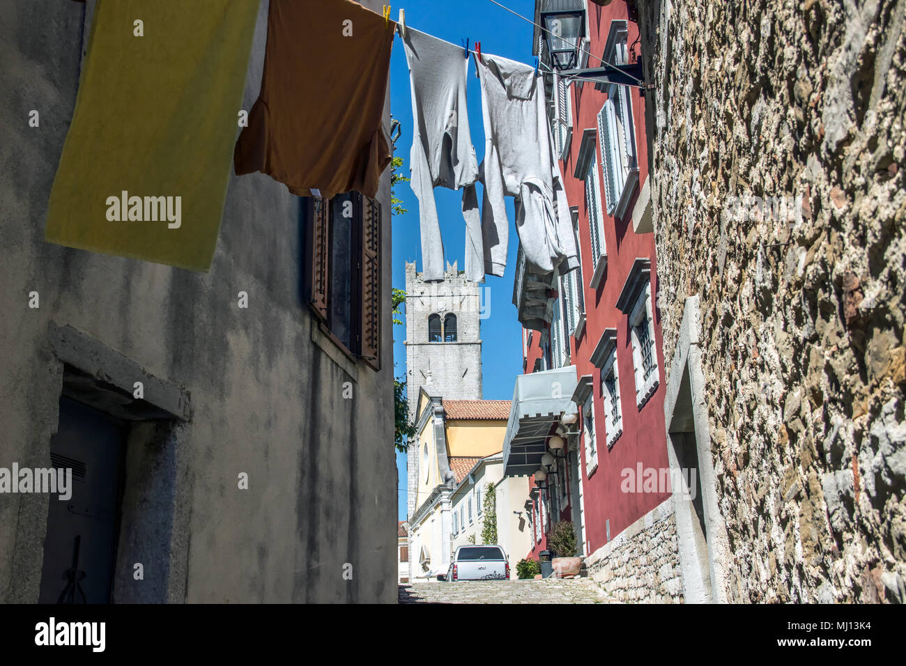 Istrien, Kroatien - Glockenturm aus einer typischen Gasse mit Kleidung trocknen auf Waschanlagen in der antiken Stadt Motovun gesehen Stockfoto