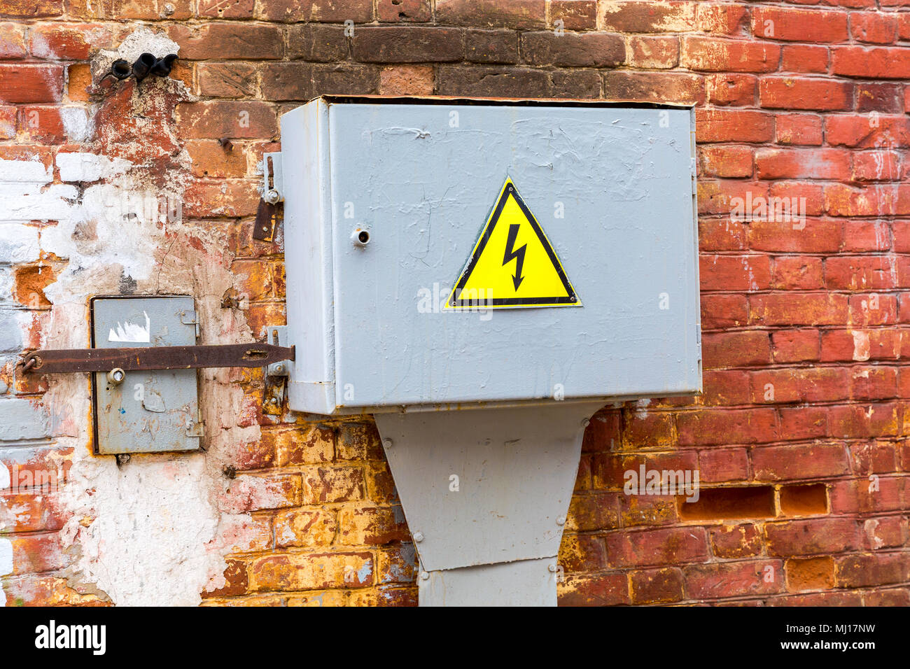 Alte gelbe hohe Spannung Warnzeichen hängen auf der metall Box mit elektrischen Anlagen Stockfoto