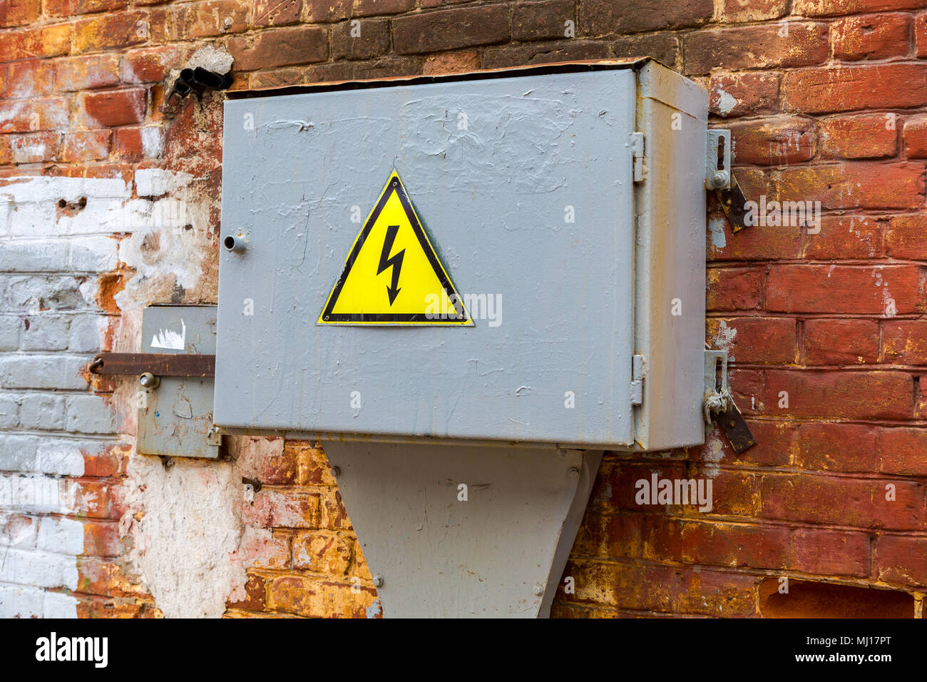 Alte gelbe hohe Spannung Warnzeichen hängen auf der metall Box mit elektrischen Anlagen Stockfoto