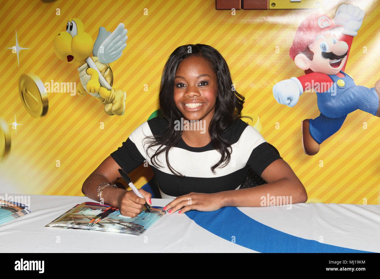NEW YORK, NY - 25. SEPTEMBER: Olympiasieger und Mario fan Gabrielle Douglas Mannschaften oben mit Nintendo für eine andere Art von Gold in New Super Mario Bros 2 Nintendo World Store in New York City zu konkurrieren. September 25, 2012. © Diego Corredor/MediaPunch Inc. Stockfoto