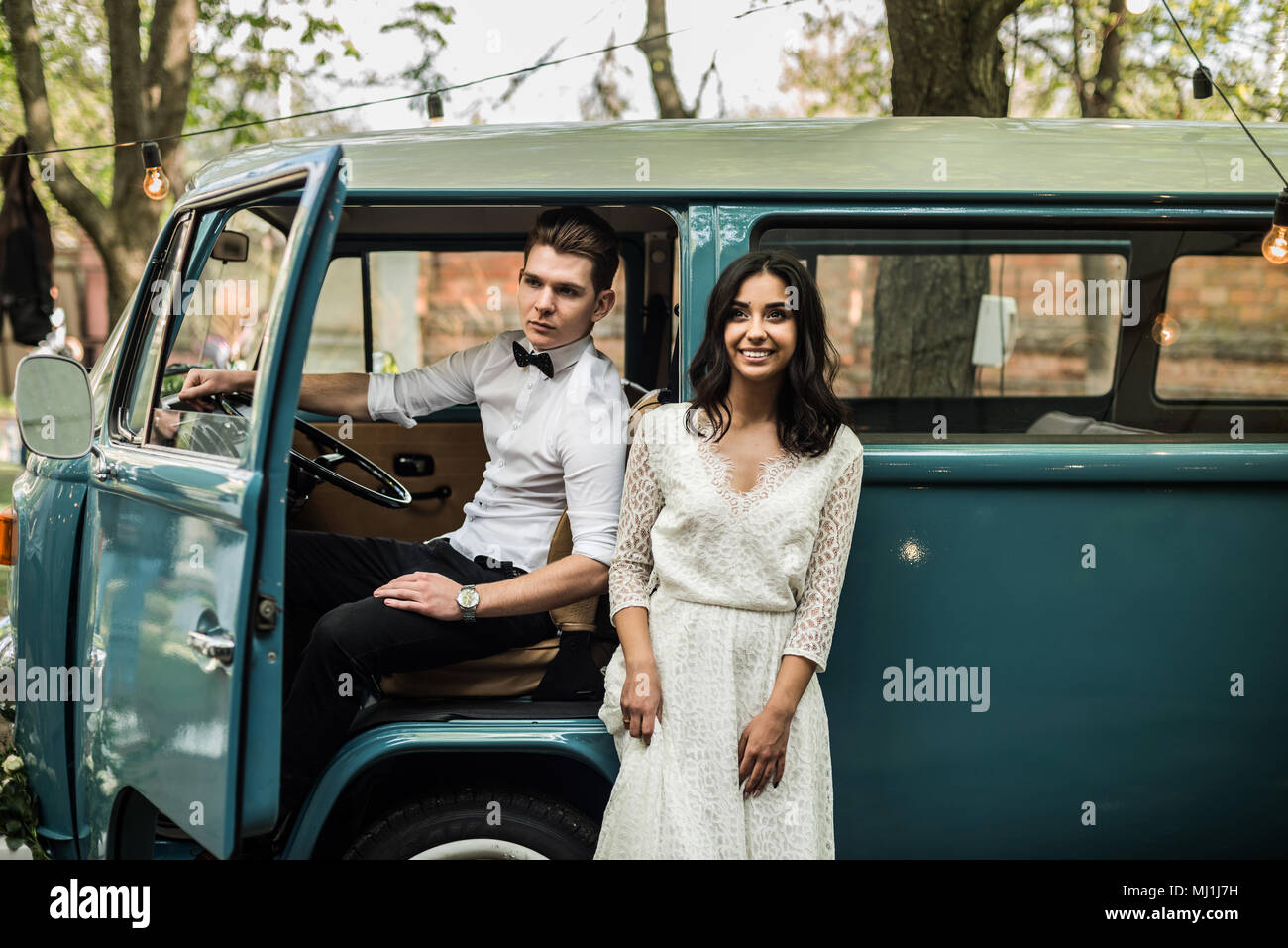 Frohes glückliches junges Paar in der Nähe von Retro minivan. Close-up Stockfoto