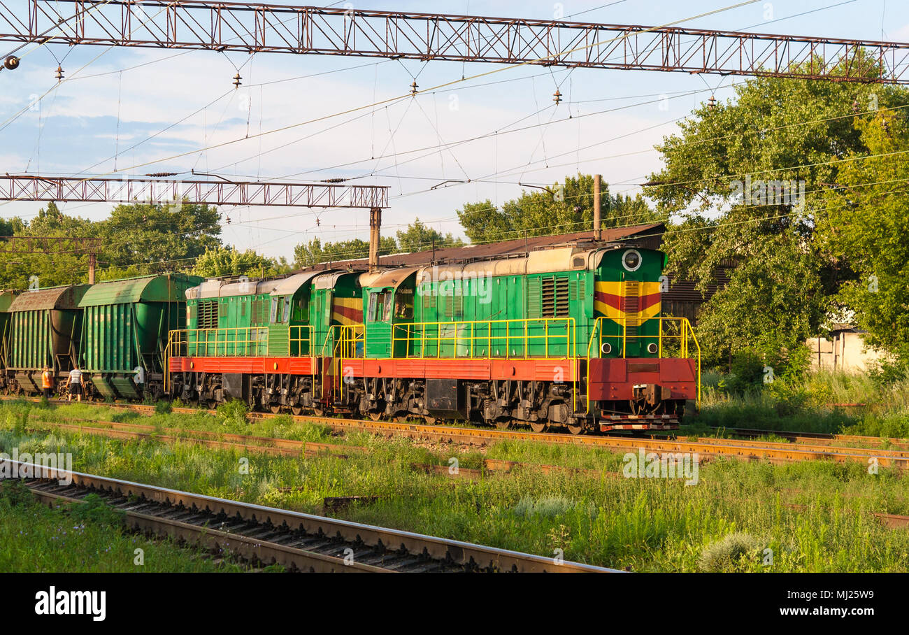 Zwei Rangierer mit Güterzug bei einer Station Stockfoto