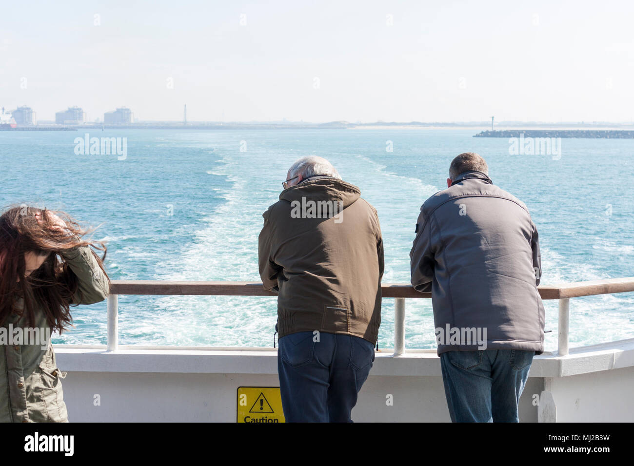 Zwei erwachsene Männchen mit Blick auf den Hafen von Dünkirchen aus dem Heck eines DFDS Ärmelkanal. Dünkirchen, Frankreich, 2018 Stockfoto