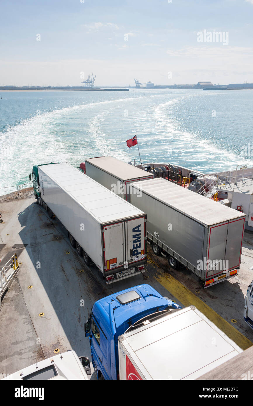 Lastkraftwagen auf der Rückseite eines ausscheidenden DFDS Seaways Fähre, mit Dunkerque Hafen in der Ferne. Dünkirchen, Frankreich, 2018. Stockfoto