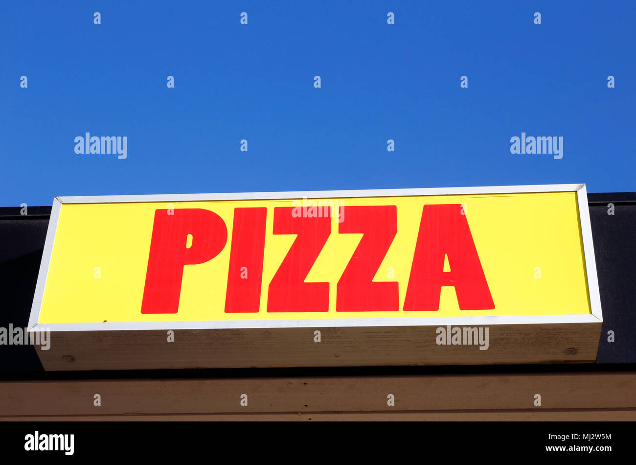 Pizza Schild mit roter Schrift auf gelben Hintergrund mit blauer Himmel über. Stockfoto