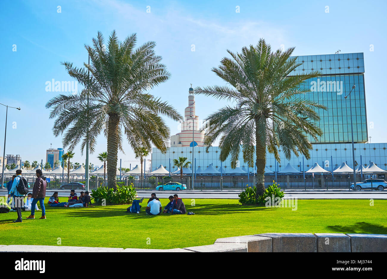 DOHA, Katar - 13. FEBRUAR 2018: Die Einheimischen genießen die tägliche Ruhezeit auf dem Picknick in Corniche mit Blick auf Spirale Minarett der Moschee Al Fanar Stockfoto