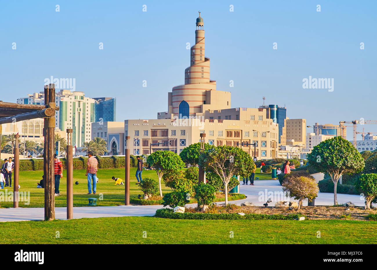 DOHA, Katar - 13. FEBRUAR 2018: die Menschen laufen und spielen in Souq Waqif park mit Spirale Minarett der Moschee Al Fanar auf Hintergrund, am 13. Februar in Stockfoto