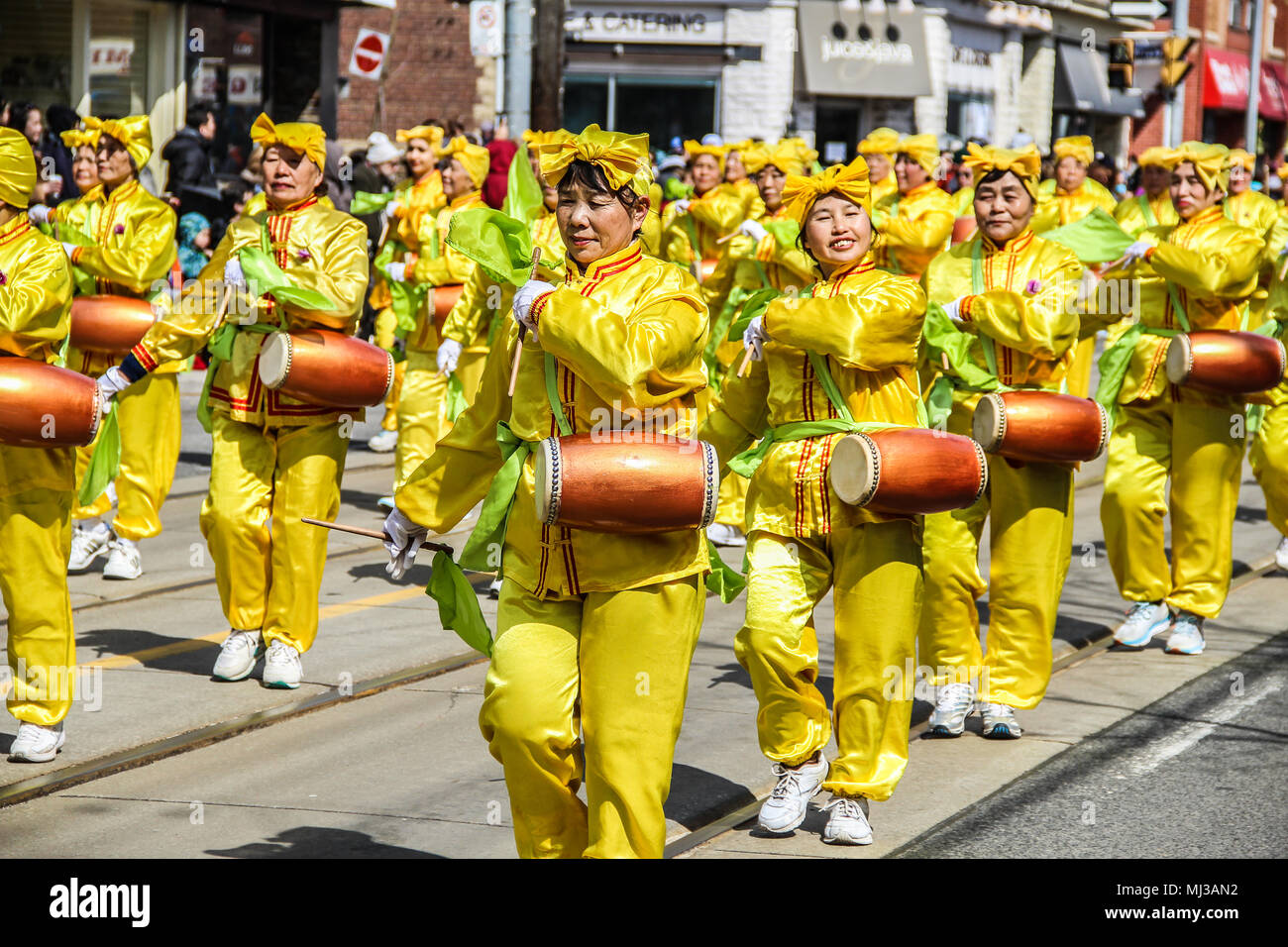 Ostern Parade in Toronto, 2018, chinesische Gemeinschaft, Frauen in gelben Kostüme Schlagzeug spielen Stockfoto