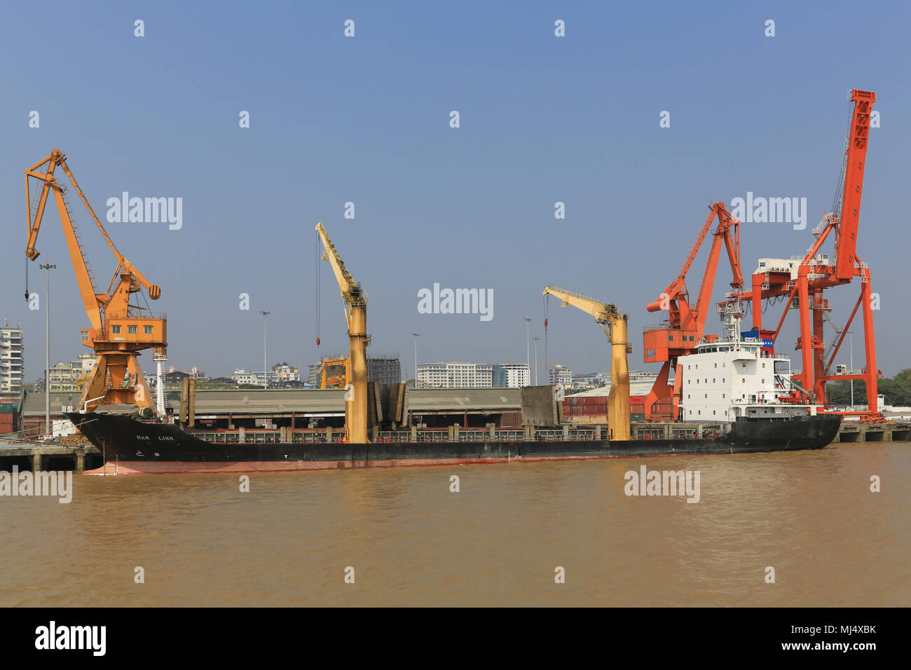 Frachtschiffe wie die Han Linn säumen die Ufer des Flusses Hafen Yangon in Myanmar (Burma) mit der Stadt Yangon Gebäude im Hintergrund. Stockfoto