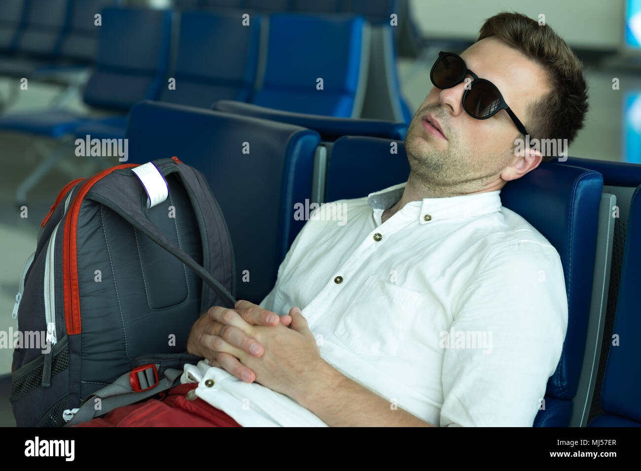 Kaukasische Mann schläft in der Lounge am Flughafen. Stockfoto