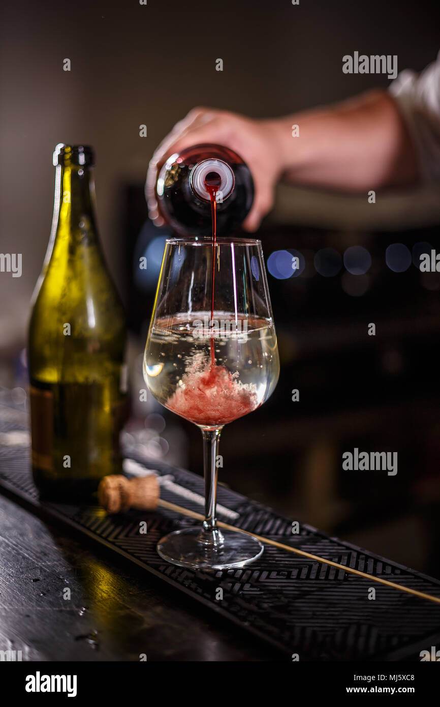 Barkeeper bereitet einen alkoholfreien Cocktail auf Champagner mit Erdbeer Sirup auf Basis Stockfoto