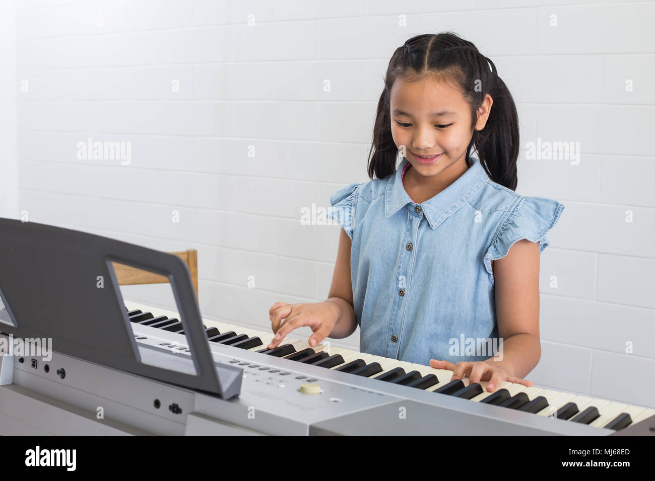 Asina Kinder Jungen Mädchen spielte Klavier in der Musik Zimmer in der Schule. Stockfoto