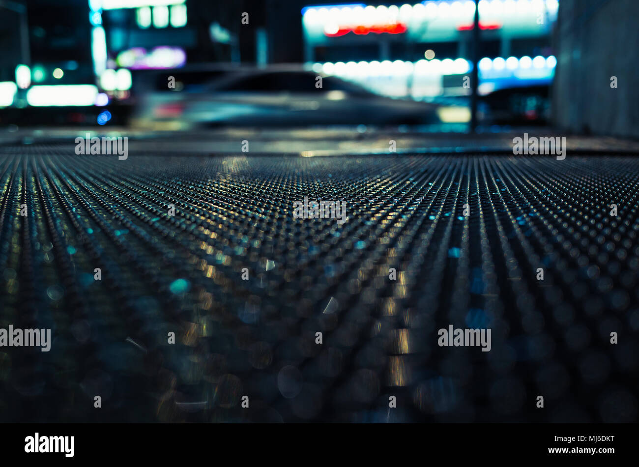 Abstrakte Nacht Stadt, Hintergrund, dunkel, nass am Straßenrand mit unscharfen Autos. Selektiver Fokus Stockfoto