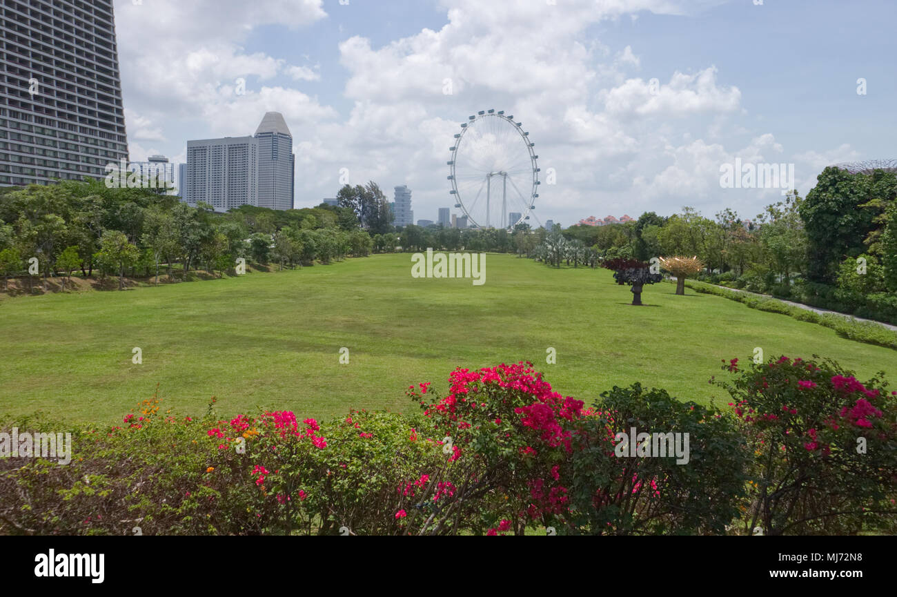 Ein stadtbild Blick auf den Eingang der Gärten durch die Bay Park in Singapur mit dem "Singapur Flyer "Riesenrad im Hintergrund. Stockfoto