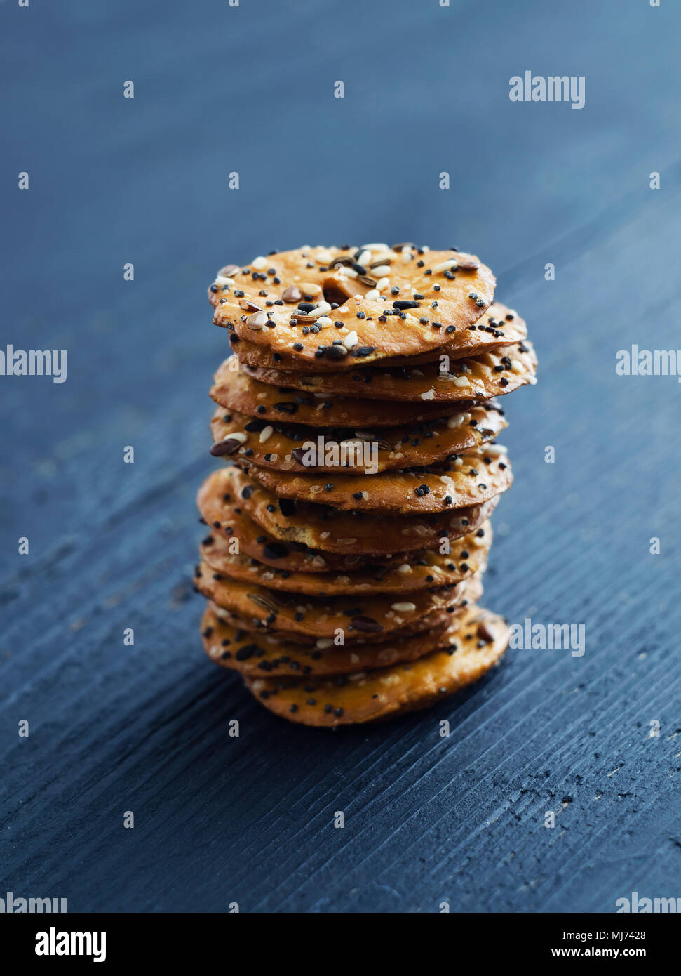 Cracker mit Mix Samen über dunklen schwarzen Holztisch Stockfoto