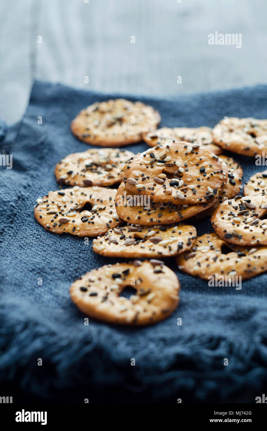 Cracker mit Mix Samen über dunklen rustikalen Hintergrund Stockfoto