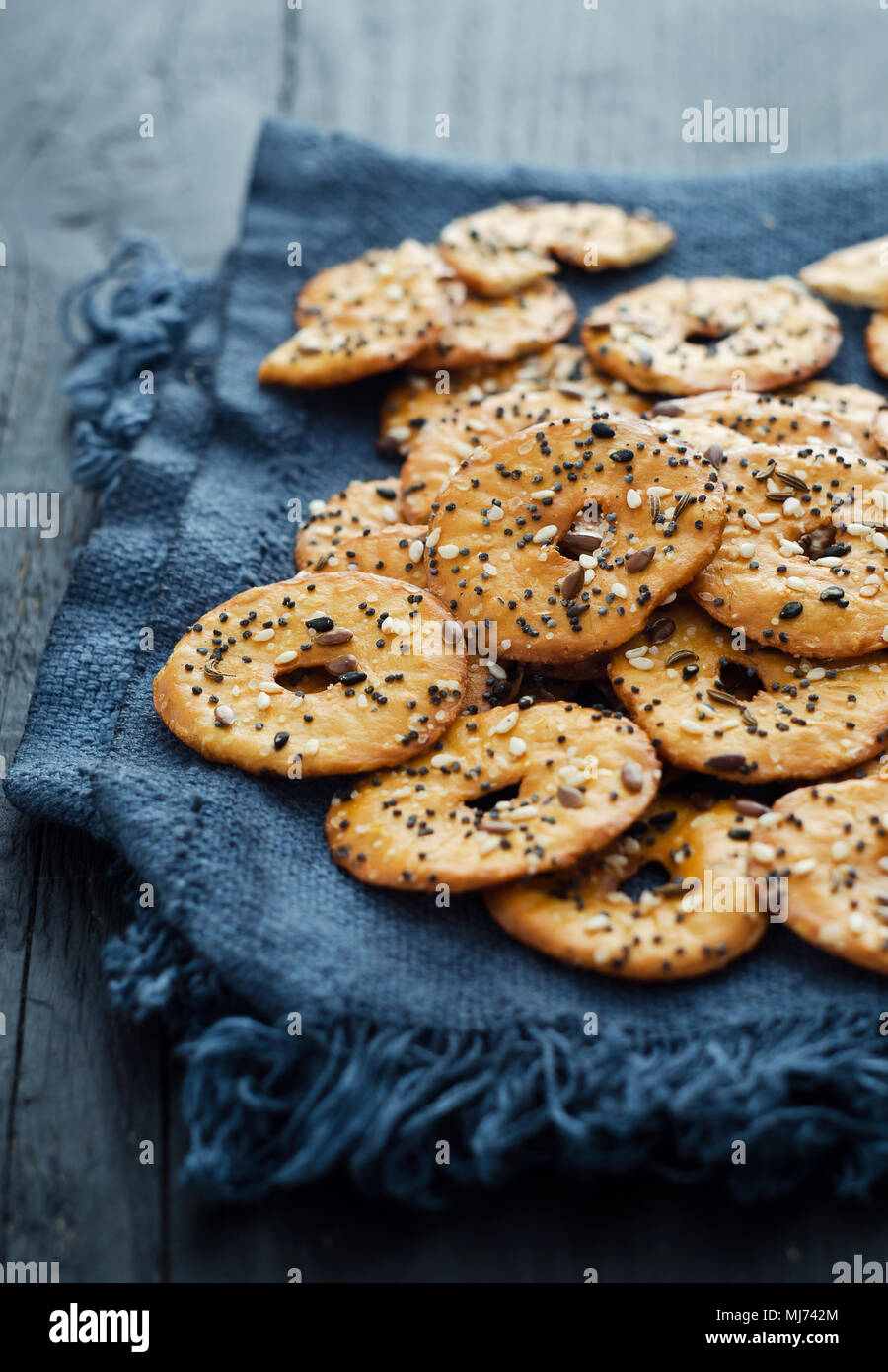 Cracker mit Mix Samen über dunklen rustikalen Hintergrund Stockfoto