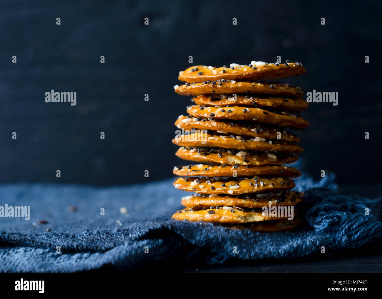 Cracker mit Mix Samen über dunklen rustikalen Hintergrund Stockfoto