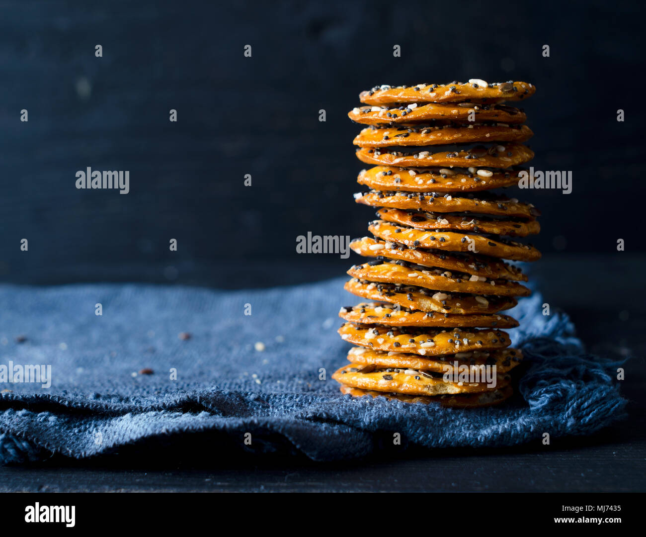 Cracker mit Mix Samen über dunklen rustikalen Hintergrund Stockfoto