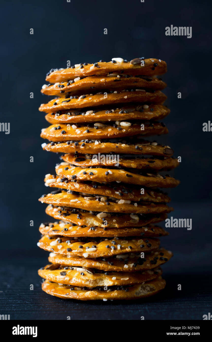 Cracker mit Mix Samen über dunklen schwarzen Holztisch Stockfoto