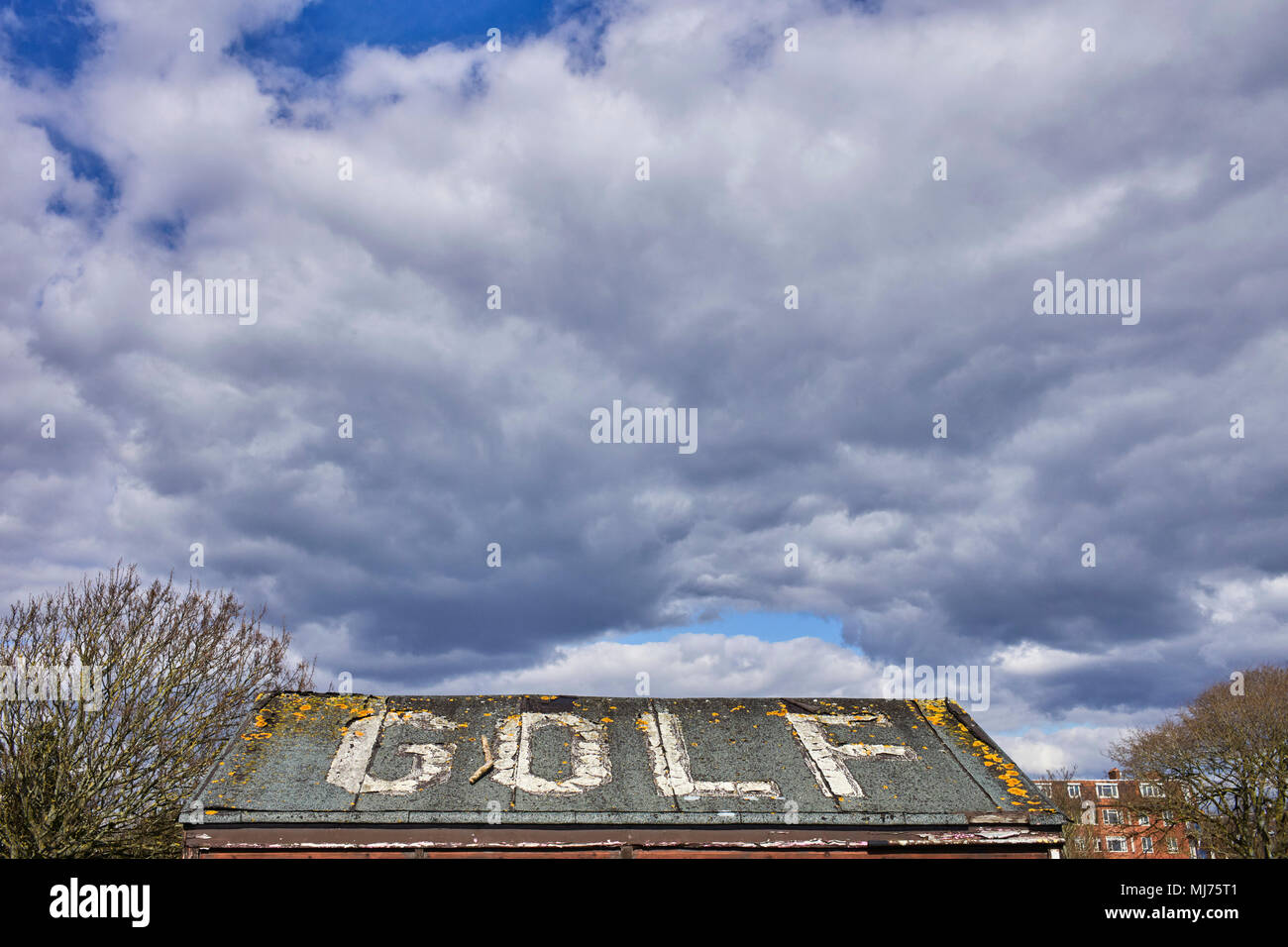 Dunkel und brütende Himmel über eine Halle mit dem Wort GOLF auf dem Dach lackiert Stockfoto