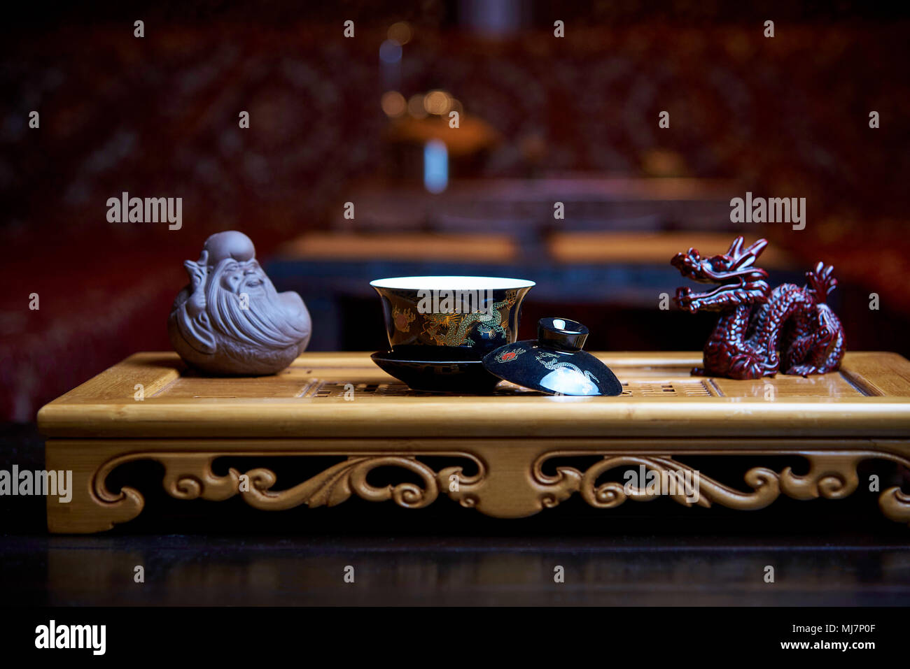 Schöne Gerichte für eine Teezeremonie close-up auf einem Holzbrett mit Statuen auf dem Hintergrund einer unscharfen Wohnzimmer. Stockfoto