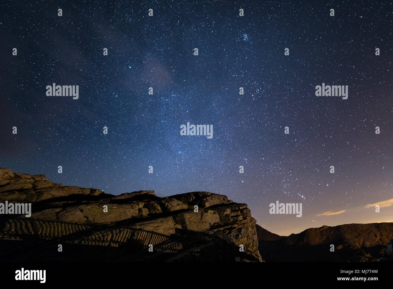 Nacht auf den Alpen unter freiem Sternenhimmel und die majestätischen Felsen auf die italienischen Alpen, mit Sternbild Orion am Horizont. Stockfoto