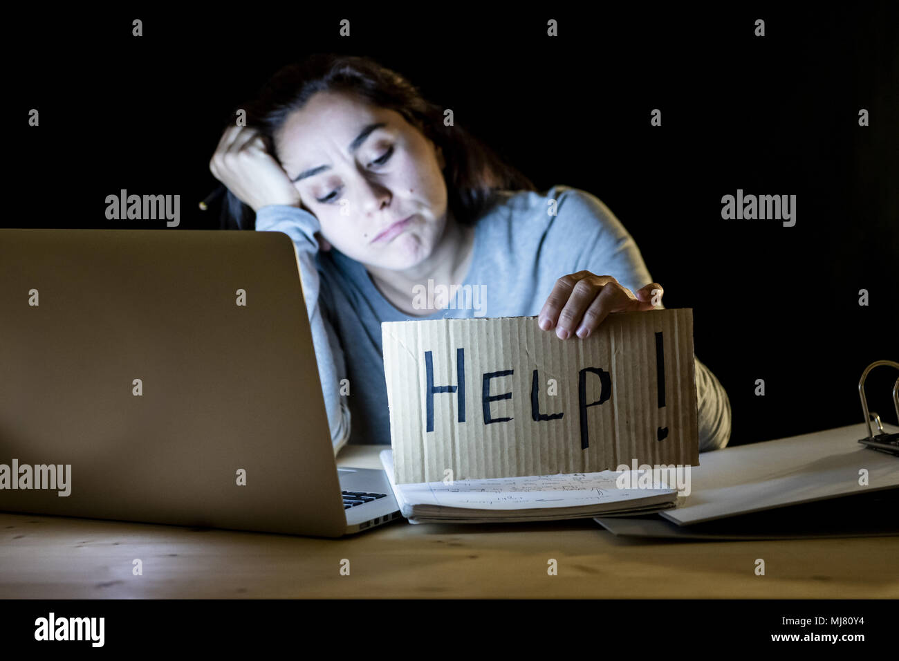 Junge müde und gestresst Student zu Hause spät in der Nacht auf Ihrem Laptop eine Hilfe Anmelden über gearbeitet und süchtig Konzept auf isolierten Bla Stockfoto