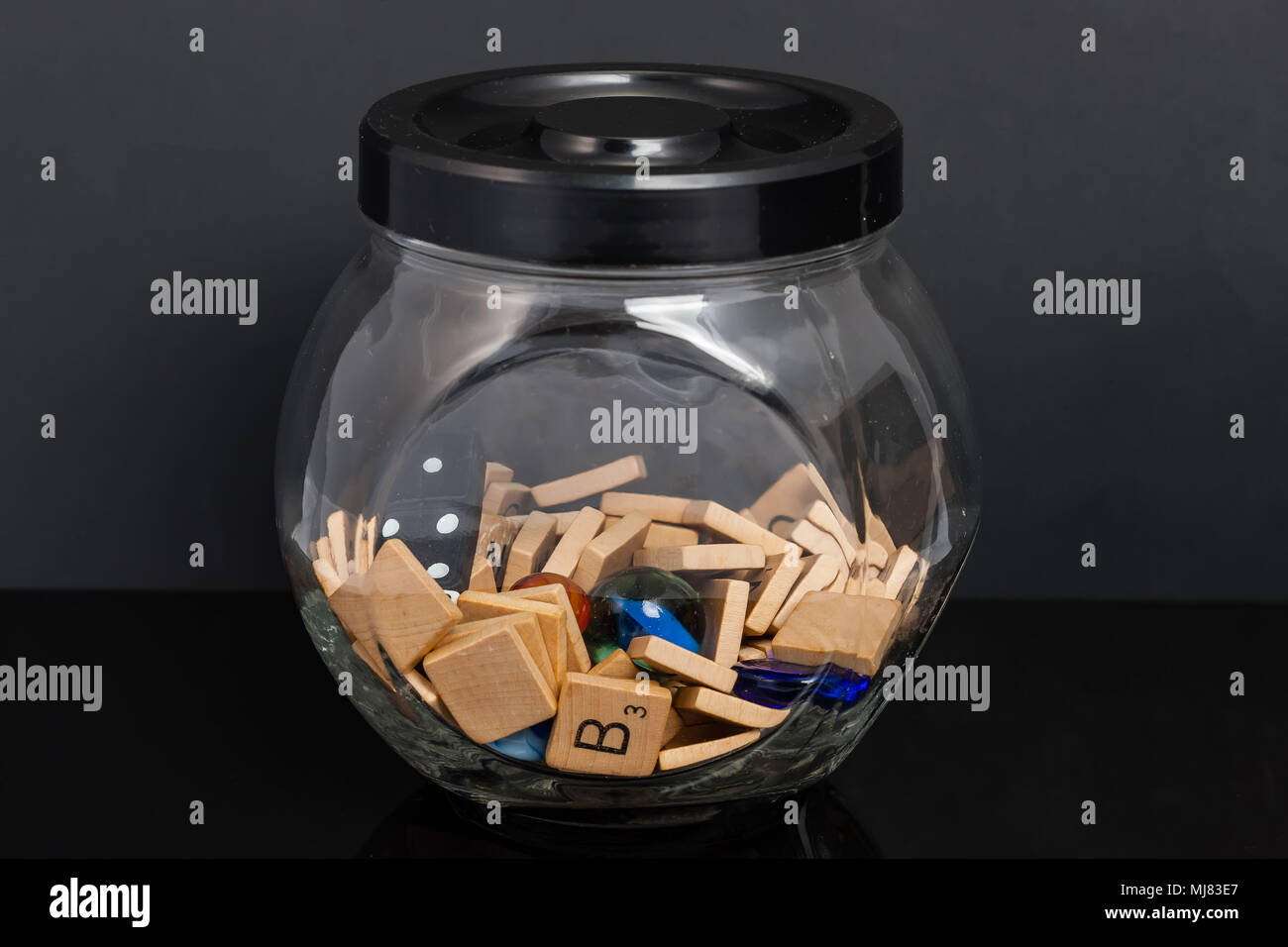 Ein Glas voll von Wort fliesen Würfel marmoriert und bunte Steine Stockfoto