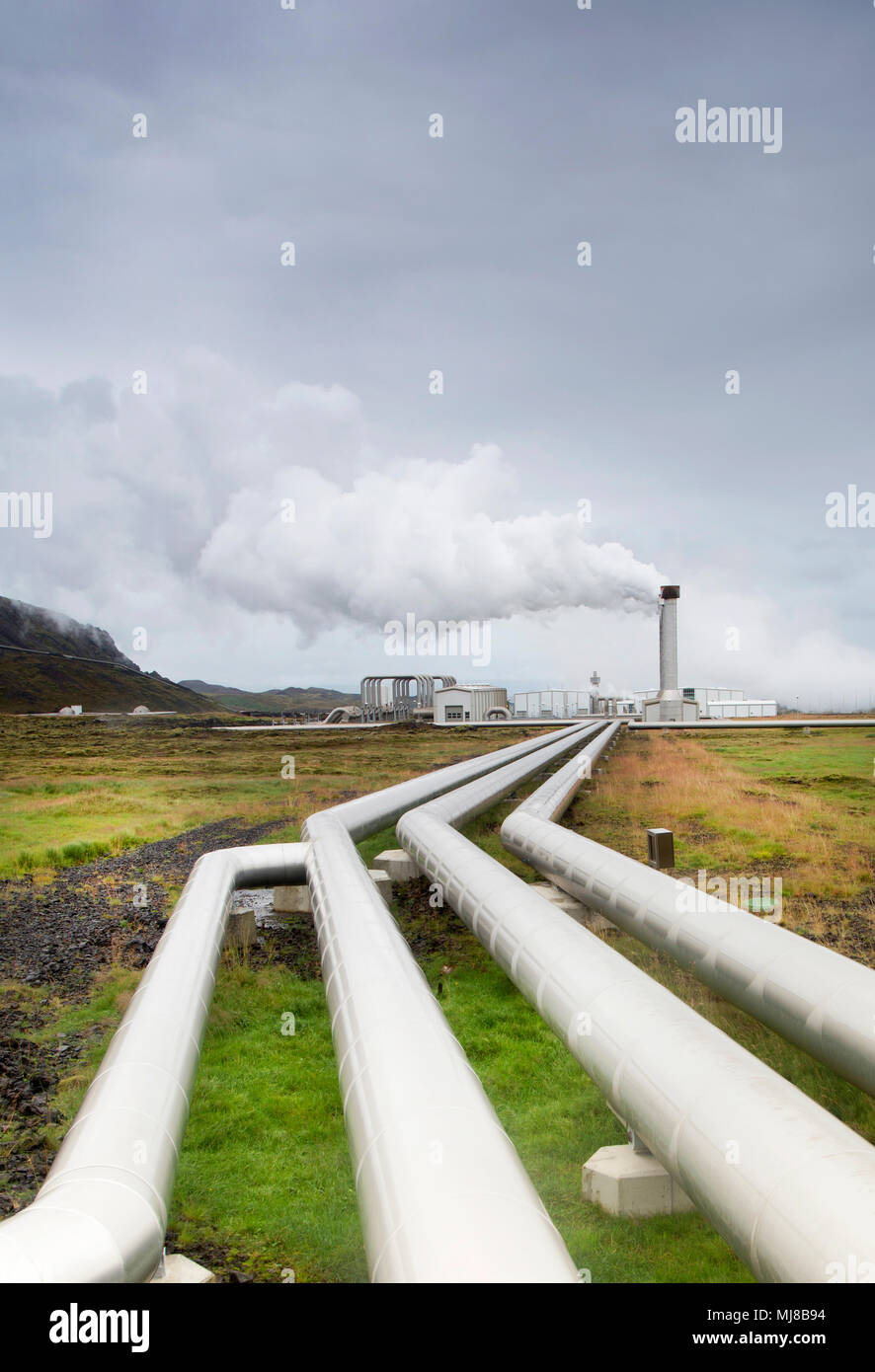 Blick entlang der Pipelines, Fabrik mit rauchenden Schornstein in der Ferne stack. Stockfoto