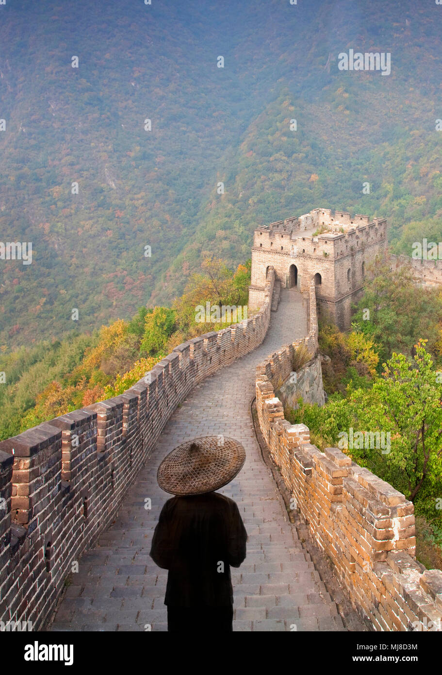 Ansicht der Rückseite des Mann mit traditionellen Strohhut stehend auf der Chinesischen Mauer. Stockfoto