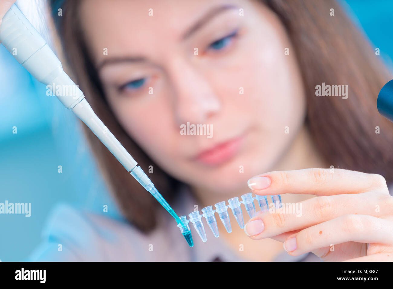 Technikerin mit Pipette in Kop für DNA die gerichtliche Prüfung Stockfoto