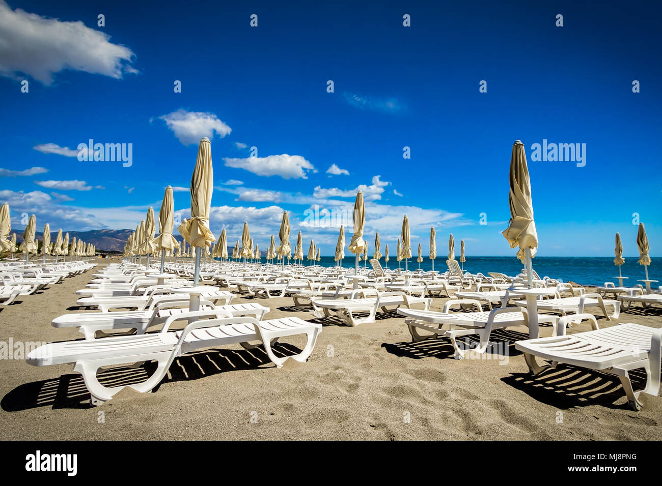 Nicht belegte Liegen in den Sand an einem sonnigen Tag im Süden Italiens. Stockfoto