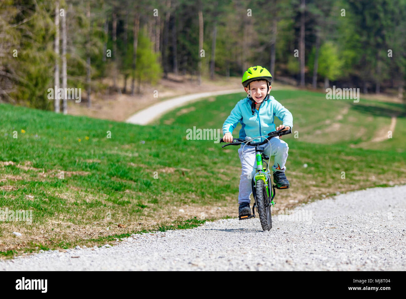 Glückliches Kind Training mit seinem Fahrrad auf Mountain Road Stockfoto