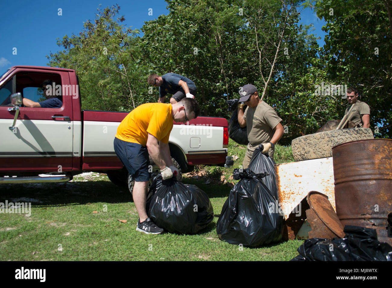 180420 - WI 626-079 Agat, Guam (20. April 2018) Segler und Familienmitglieder zu Submarine Squadron (SUBRON) 15 und Performance Monitoring Team (PMT) Loslösung Guam Abholung Papierkorb hinter dem Friedhof in Agat, Guam, April 20 zugeordnet. Mehr als 20 freiwillige Helfer aus dem SUBRON 15 und PMT Loslösung Guam zusammengetan, um mehr als 40 Säcke Müll und Schmutz in Agat Pick als Teil einer Masse Tag clean-up. (U.S. Navy Foto von Leutnant Lauren Spaziano/Freigegeben) Stockfoto