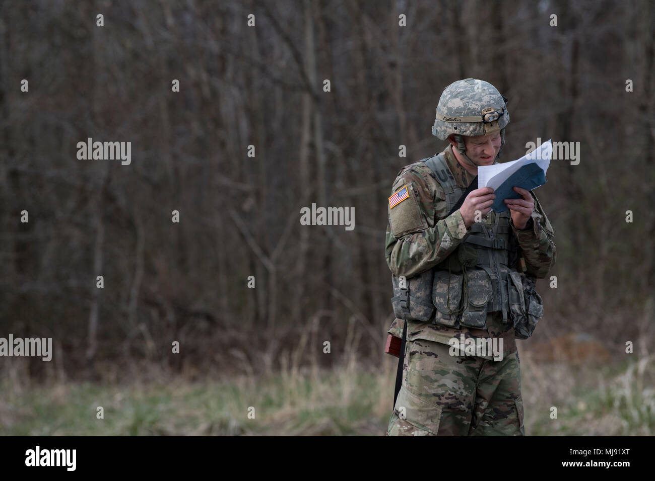 Ein West Virginia Army National Guard Soldat liest Koordinaten aus einer Karte, wie er versucht, Ziele während der besten Krieger Wettbewerb in die Hinterwälder von Preston County, W. Virginia ausfindig machen April 21, 2018. 15 Soldaten und Piloten von der West Virginia Armee und Air National Guard und vier aus dem D.C. Army National Guard in den dreitägigen Wettbewerb demonstriert am besten Krieger Krieger Aufgaben wie die körperliche Fitness, hindernisparcours Abschluss konkurrierte, Waffen, Qualifikation, ruck marschieren und Land Navigation. (U.S. Air National Guard Foto von Airman 1st Class Kaleb Vance) Stockfoto