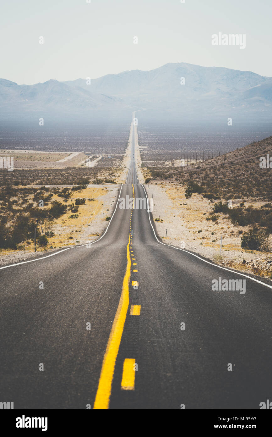 Classic panorama Blick auf eine endlose gerade Straße durch die karge Landschaft des amerikanischen Südwestens läuft Stockfoto Classic panorama Blick auf eine endlose gerade Straße durch die karge Landschaft des amerikanischen Südwestens läuft Stockfoto
