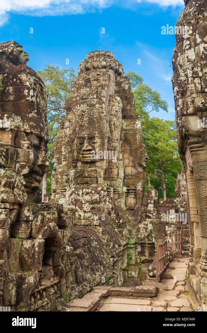 Turm mit alten Gesicht Skulpturen neben dem zentralen Heiligtum der Kambodschanischen Bayon Tempel in Angkor. Stockfoto