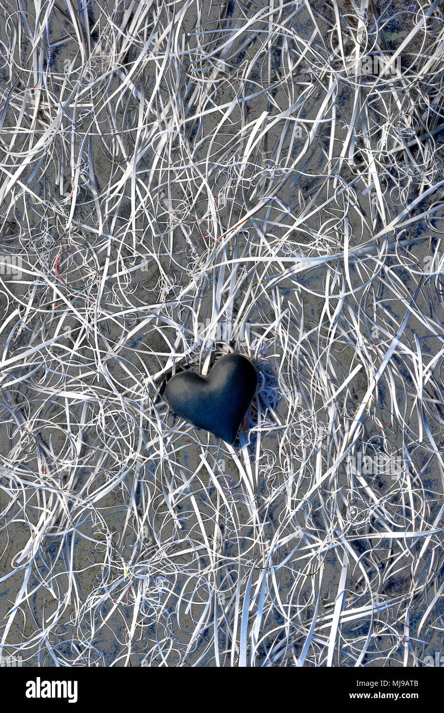 Das dunkle Herz in der Mitte von einem Gewirr von Karte Reste auf einem Hintergrund von Schiefer. Stockfoto