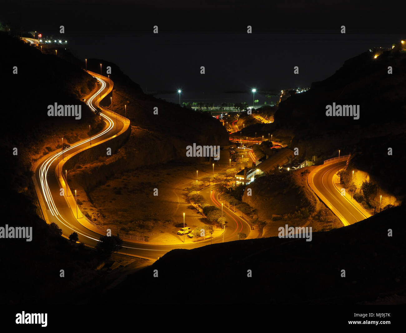 Kurvenreiche Straße beleuchtet mit Straßenbeleuchtung Stockfoto