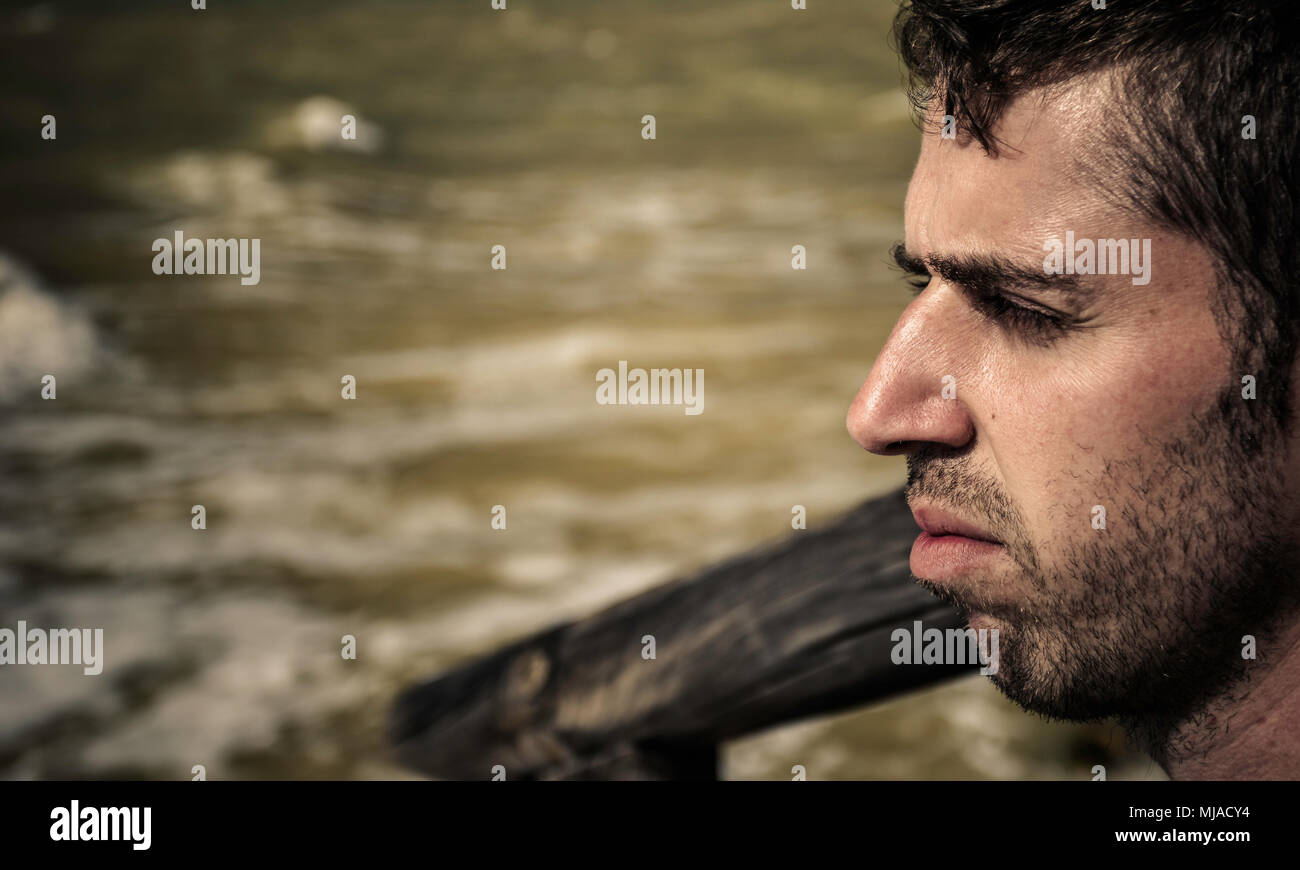 Portrait des jungen Mannes mit dem Meer im Hintergrund Stockfoto