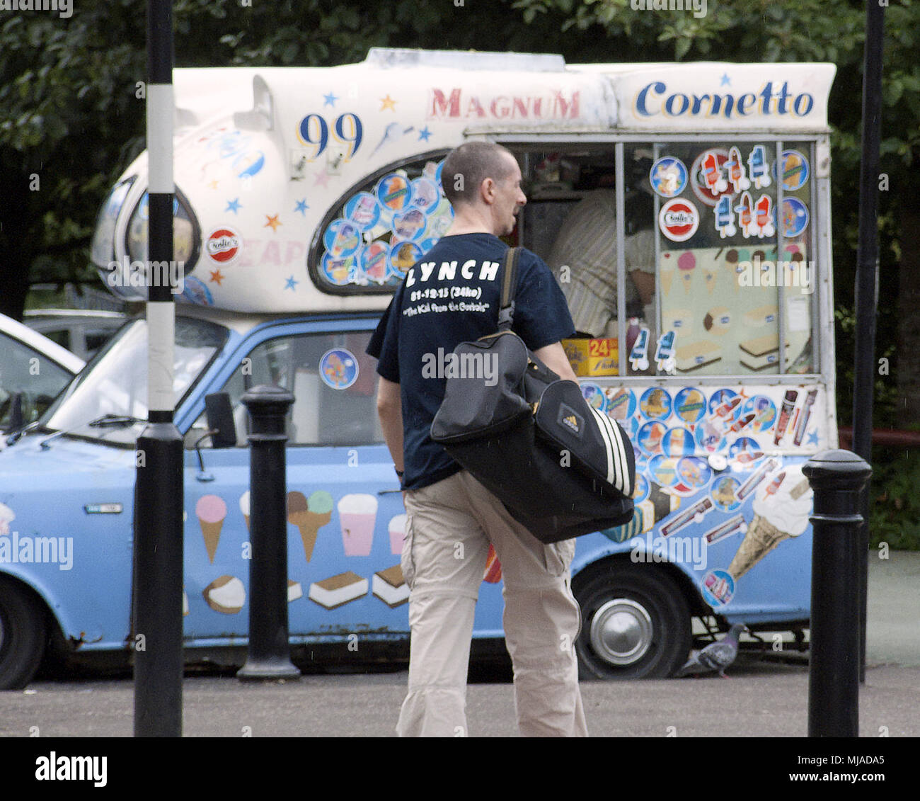 Mann zu Fuß von der Turnhalle in den gorbals Bereich von Glasgow mit Held benny Lynch t-shirt Vor vintage ice cream van mobile Shop Stockfoto