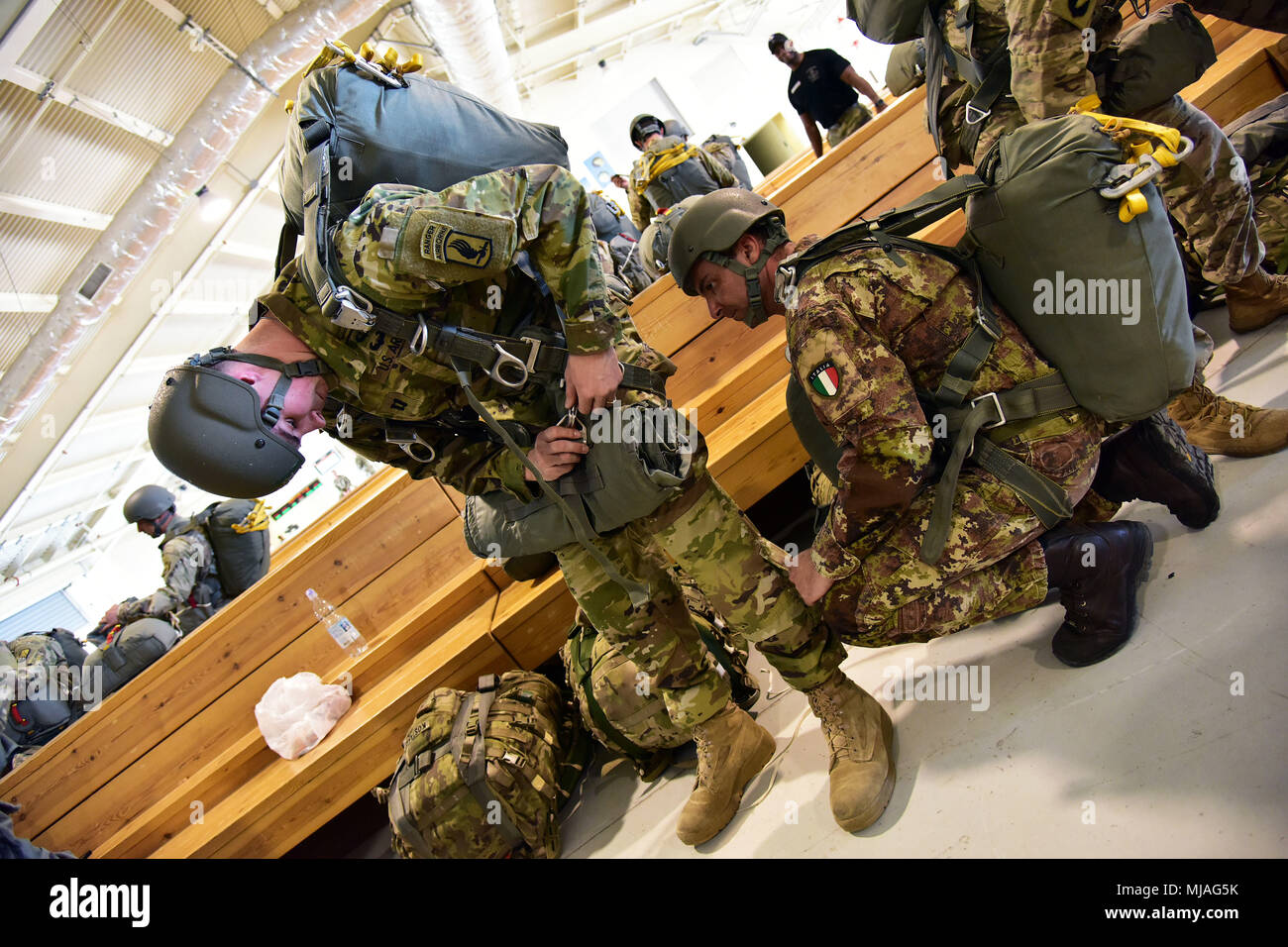 Italienische Heer Fallschirmjäger zu Folgore Brigade zugeordnet, kontrolliert die Fallschirm mit US-Armee Fallschirmjäger auf die 173Rd Airborne Brigade, während Jumpmaster Qualifikation, bei Aviano Air Base vor dem luftgestützten Hilfsaktionen auf Frida Drop Zone in Pordenone, Italien, 23. April 2018 führen. (U.S. Armee Foto von Paolo Bovo) Stockfoto