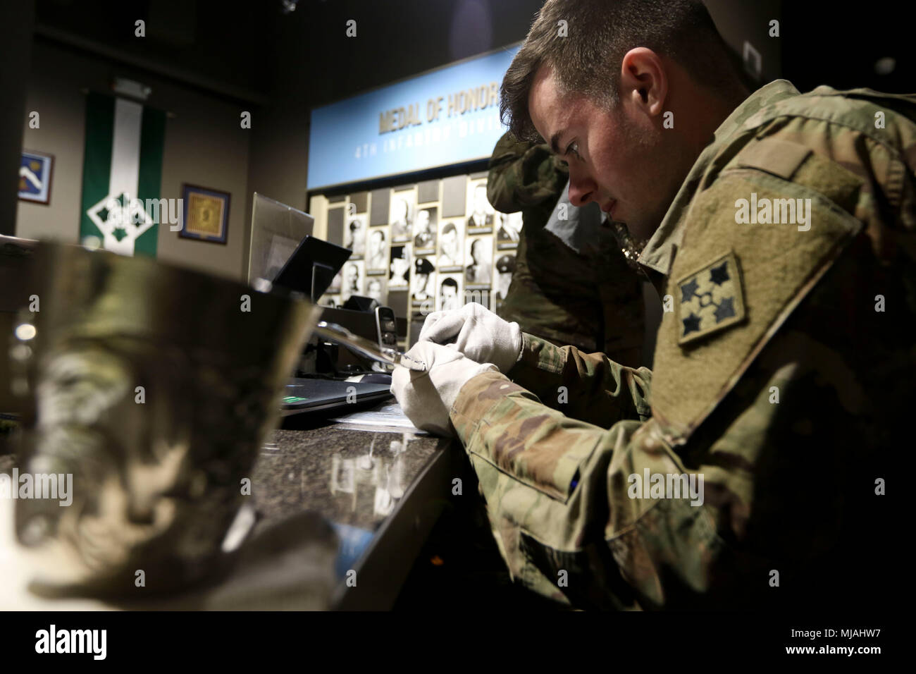 Spc. Zach Ambrosius von 1St Battalion, 38th Infantry Regiment, 1 Stryker Brigade Combat Team, 4 Infanterie Division poliert Die über zwei Fuß lange silberne Schöpfkelle, dass die Liscum Schüssel am 24. April 2018 begleitet, vor der Enthüllung der reich verzierten Artefakt am Fort Carson Museum in Fort Carson, Colorado. Die Liscum Schüssel ist ein silber Punch Bowl, von mehr als 90 Pfund Silber Goldbarren, die von den 9 Infanterie Regiment während der Boxeraufstand 1900 beschlagnahmt wurde und mit dem Regiment als Zeichen der Anerkennung für seine Tätigkeit während des Konflikts vorgelegt. Die Schüssel hatte auf der Anzeige. Stockfoto