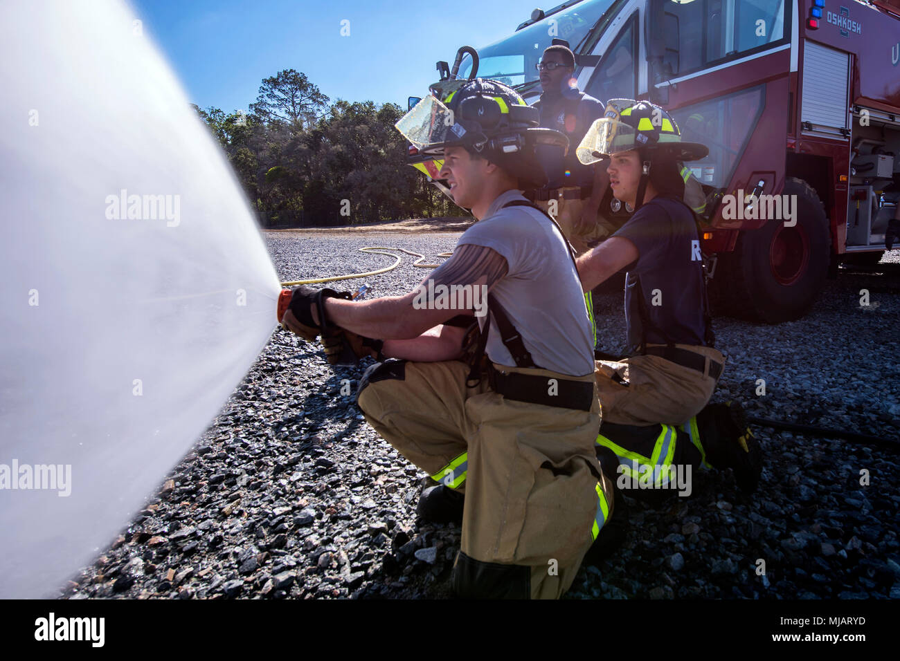 Feuerwehrmänner vom 23 d Bauingenieur Squadron (CES) Spray ein Schlauch während der Live-Fire Training, 24. April 2018, bei Moody Air Force Base, Ga Feuerwehrmänner vom 23 d CES und Valdosta Feuerwehr in der Ausbildung mehr Erfahrung Löschflugzeuge Brände zu gewinnen und zusammen als ein geschlossenes Team zu arbeiten, während Sie noch üben ordnungsgemäße und sichere Brandbekämpfung Techniken beteiligt. (U.S. Air Force Foto von Airman 1st Class Eugene Oliver) Stockfoto