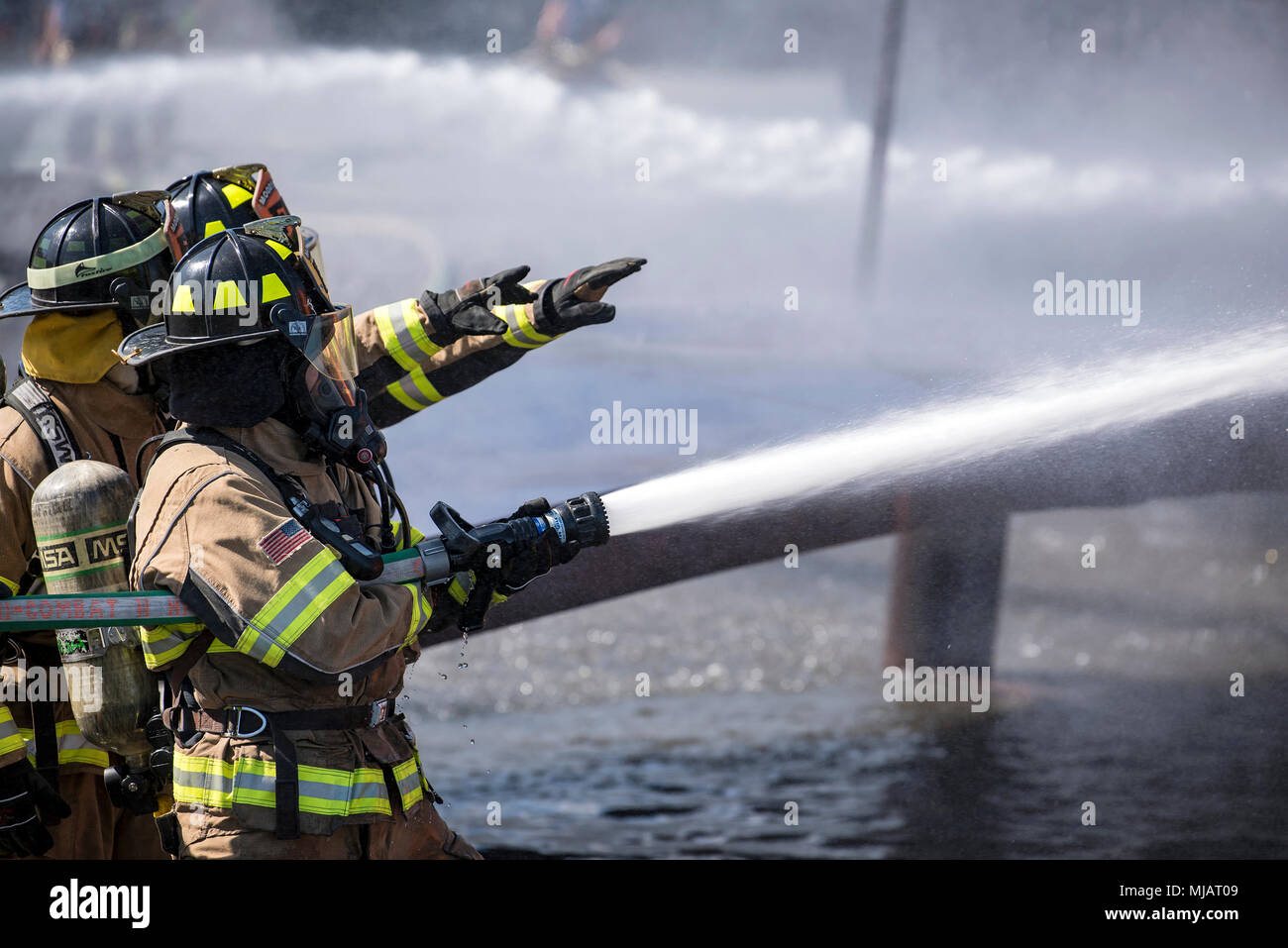 Feuerwehrmänner vom Valdosta Feuerwehr (VFD) Signal an Feuerwehrleute aus den 23d Bauingenieur Squadron während der Live-Fire Training, April 25, 2018, bei Moody Air Force Base, Ga Feuerwehrmänner vom 23 d Bauingenieur Squadron und VFD nahmen an der Ausbildung mehr Erfahrung Löschflugzeuge Brände zu gewinnen und zusammen als ein geschlossenes Team zu arbeiten, während Sie noch üben ordnungsgemäße und sichere Brandbekämpfung Techniken. (U.S. Air Force Foto von Airman 1st Class Eugene Oliver) Stockfoto