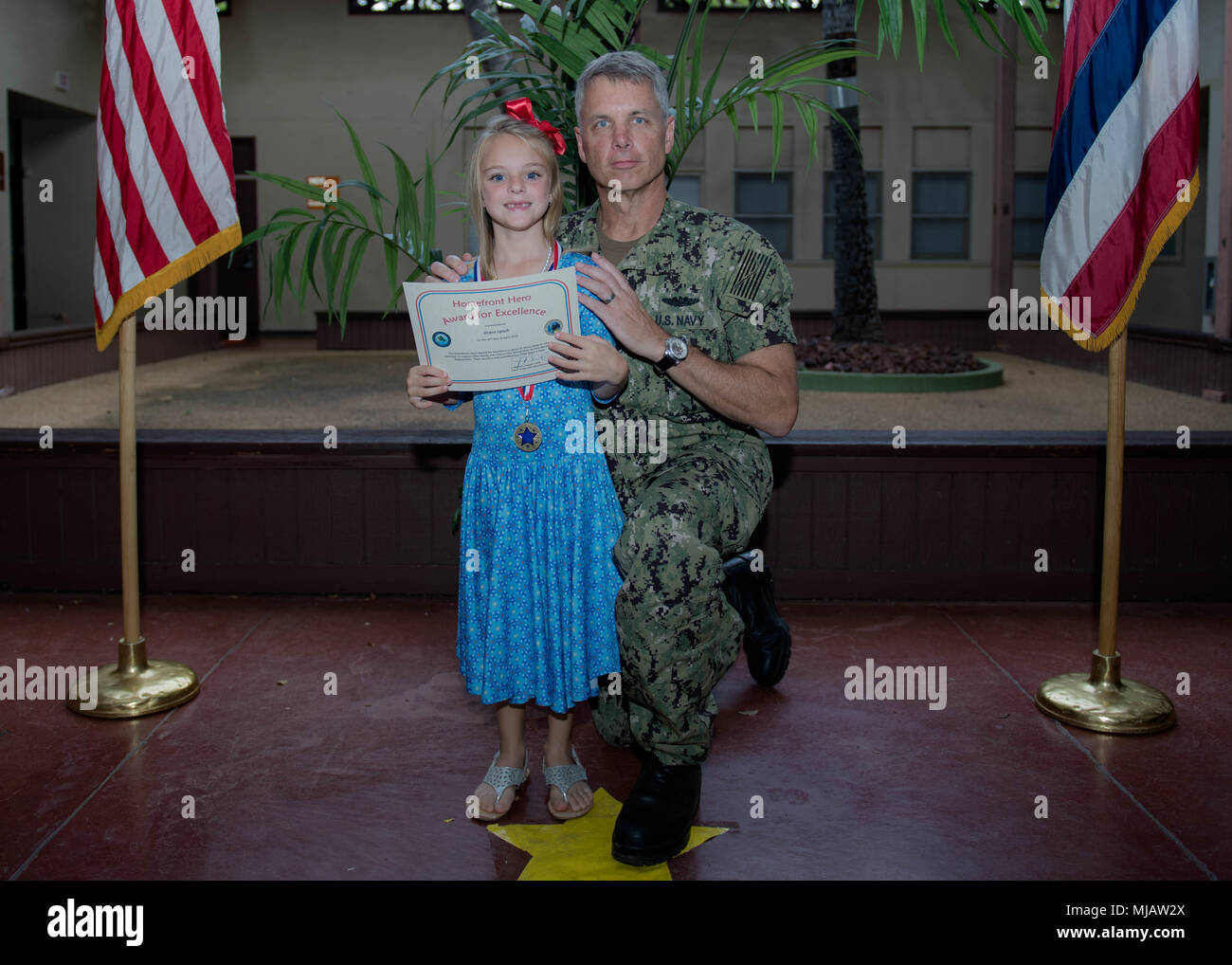 180426-N-ND 356-0061 Pearl Harbor (Apr. 26, 2018) ein Homefront Hero Award Empfänger erhält eine Urkunde von Kapitän Jeff Bernard, Kommandeur der Joint Base Pearl Harbor-Hickam an einer militärischen und Family Support Center unter Joint Base Pearl Harbor-Hickam. Die Homefront Hero Award wurde in einer Unterstützung der Monat der militärischen Kind erstellt. (U.S. Marine Foto von Mass Communication Specialist 3. Klasse Jessica O. Blackwell) Stockfoto